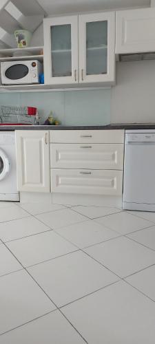 La cuisine est équipée de placards blancs et d'un lave-vaisselle. dans l'établissement maison pour vacance a la mer, à Port-la-Nouvelle