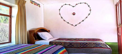 a room with two beds and a heart on the wall at Lake House Occosuyo Isla Amantani in Amantani