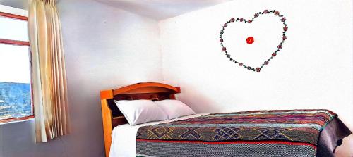 a bedroom with a bed with a heart on the wall at Lake House Occosuyo Isla Amantani in Amantani