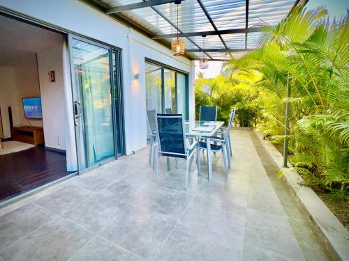 a dining room with a table and chairs on a patio at Appartement avec jardin Cap Malheureux in Cap Malheureux