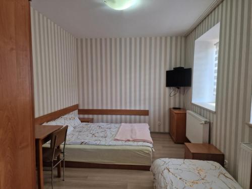 a hotel room with two beds and a desk at Noclegi Ali in Wałbrzych