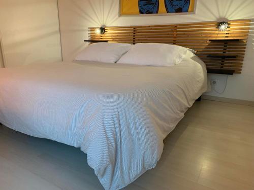 - un grand lit blanc dans une chambre avec deux lumières dans l'établissement Le Petit Bruxelles au calme, à Toulouse