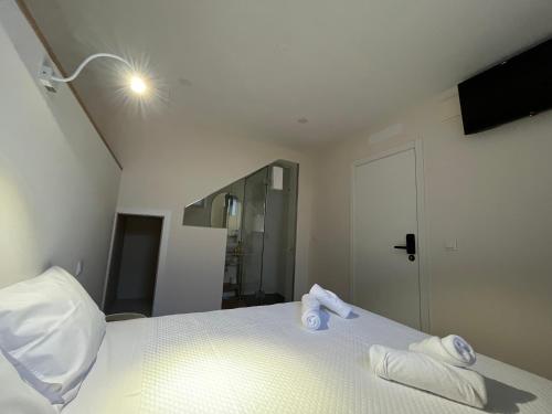 a bedroom with a bed with two towels on it at Ameixial Suites in Porto