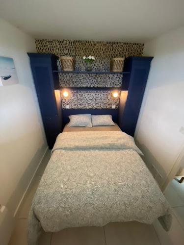 - une petite chambre avec un lit doté d'une tête de lit bleue dans l'établissement Charmant appartement en front de mer avec piscine, à Lacanau-Océan