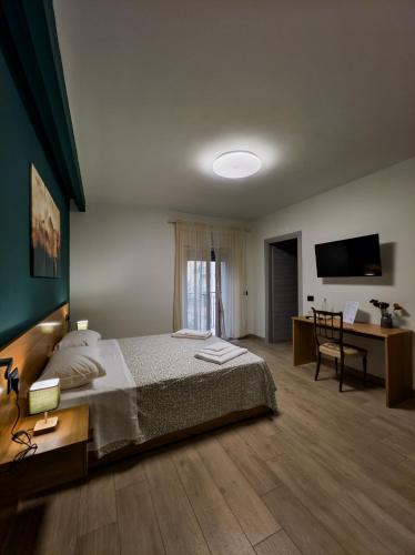a bedroom with a bed and a desk and a television at Borgo dei cervi B&B in Villalago