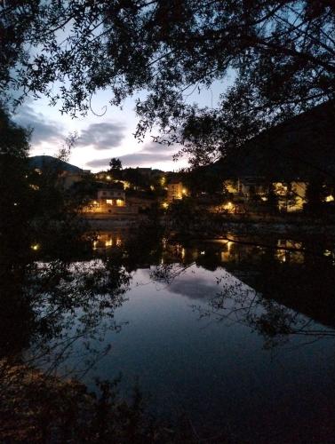 a night view of a lake with buildings and lights at Borgo dei cervi B&B in Villalago