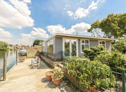 a tiny house on the water with a dock at RIVER RETREAT- near Holloway U, Thorpe Park and Heathrow airport in Thorpe