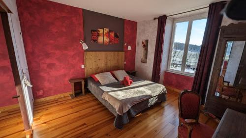 une chambre avec un lit et un mur rouge dans l'établissement Chambres et tables d' hôtes, à Manglieu