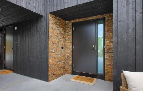 a large black door in a brick wall at Stunning Home In Lyngdal With Kitchen in Lyngdal