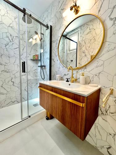 une salle de bain avec un lavabo et une douche dans l'établissement Villa années 30, bords de Marne, à Joinville-le-Pont