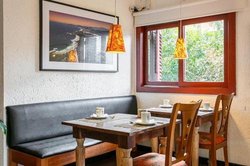 a dining room with a table and a bench at Pousada Casa da Lagoa in Florianópolis