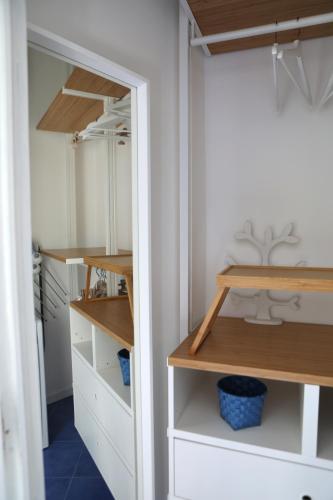a closet with white cabinets and wooden shelves at Kalè in Giovinazzo