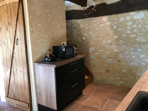 a room with a microwave on top of a dresser at Logis de Chaumiac in Bouniagues