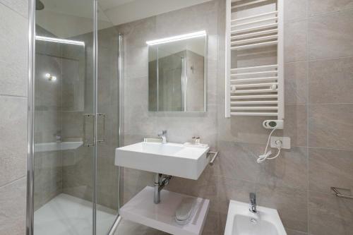 ein Badezimmer mit Waschbecken, Dusche und Spiegel in der Unterkunft ELICAL Vatican Suites in Rom