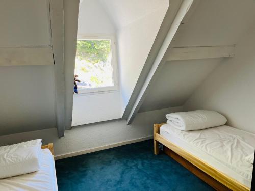 deux lits dans une petite pièce avec une fenêtre dans l'établissement appartement vue sur lac, à Laruns