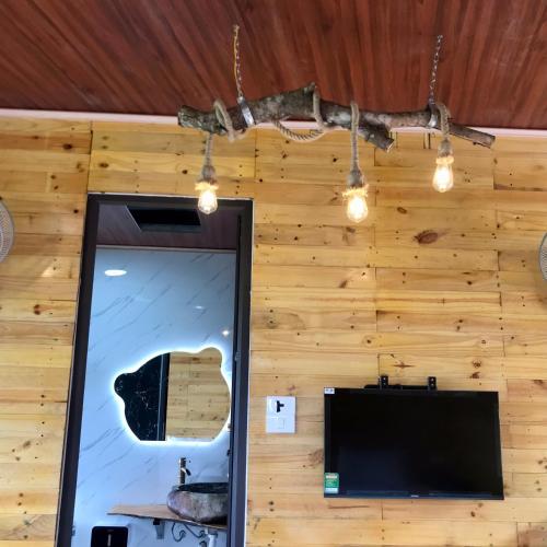 a room with a mirror and a guitar on the wall at A Thía homestay in Diện Biên Phủ