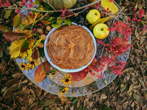 a bowl of peanut butter on a plate with apples and flowers at Guest House Brili in Ghebi in Ghebi