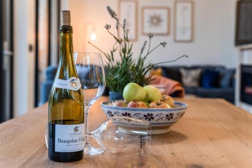a bottle of wine and a bowl of apples on a table at Drumhierny Woodland Hideaway in Leitrim