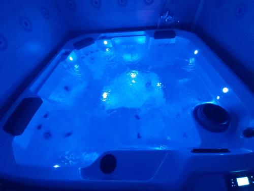 a bath tub with blue lights in a room at Pensiunea Pastravaria Vistisoara in Vistisoara