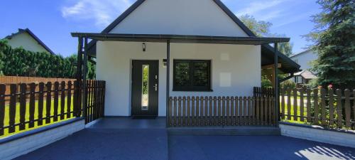 a small white house with a black door at Tarnów Velo Apartament - Dom in Tarnów
