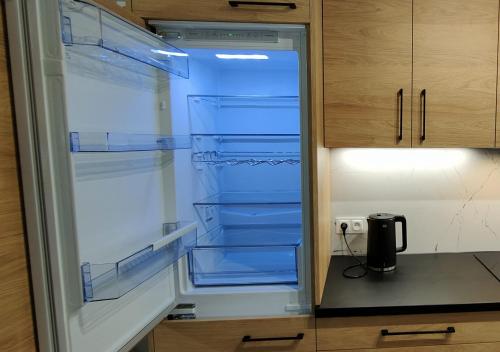 an empty refrigerator with its door open in a kitchen at Tarnów Velo Apartament - Dom in Tarnów