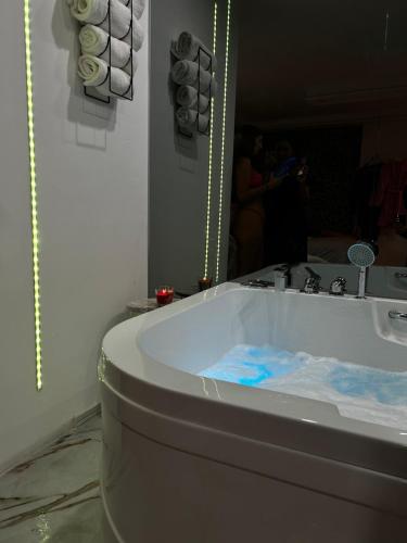 a bath tub in a bathroom with a mirror at Love spa apartman in Banja Koviljača