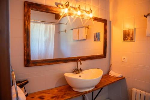 a bathroom with a white sink and a mirror at Minds & Mountains Eco Lodge in La Molina