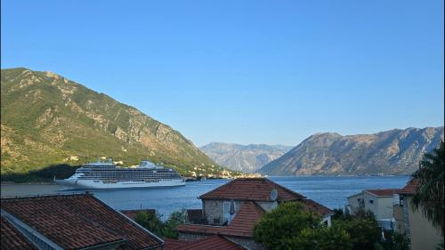 a cruise ship is docked in a bay with mountains at Lux Seaside Residence in Kotor