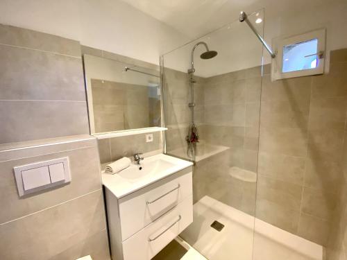 un bagno bianco con lavandino e doccia di Mini-villa Bocca del Oro - Sud Porto-Vecchio a Bocca del Oro