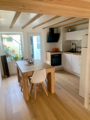 une cuisine avec une table en bois et des armoires blanches dans l'établissement Maison - Centre-ville - équipée, à Niort