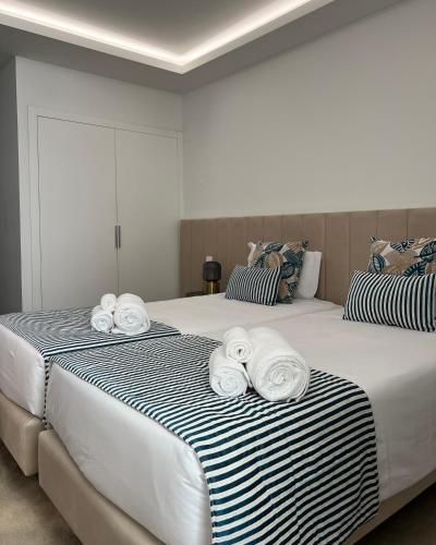 two beds with towels on top of them in a bedroom at BLUE ANCORA HOTEL in Vila Praia de Âncora