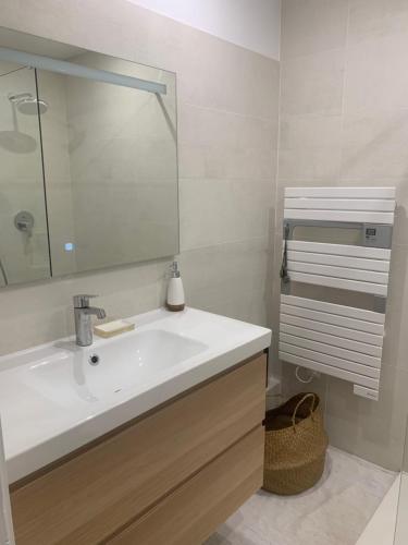 une salle de bain avec un lavabo blanc et un miroir dans l'établissement Maison - Centre-ville - équipée, à Niort