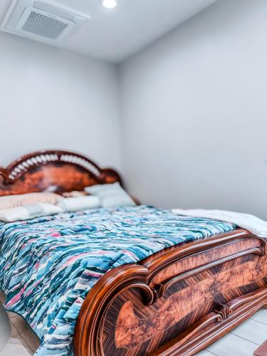 a bed with a wooden headboard and a laptop on it at Luxurious room in Fall River Stay in Fall River