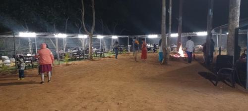 a group of people standing in a field at night at Elgozo Hotel Dreams Parasise in Yercaud