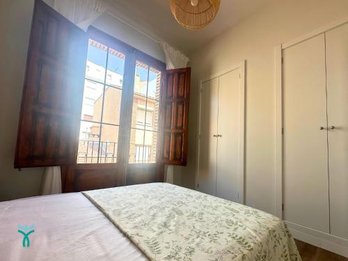 a bedroom with a large bed and a window at Dos Torres Refugio in Zaragoza