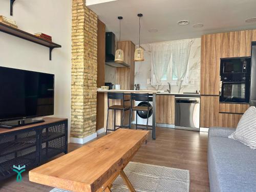 a living room with a couch and a tv and a kitchen at Dos Torres Refugio in Zaragoza