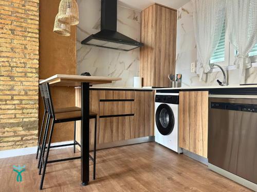 a kitchen with a counter and a washer and dryer at Dos Torres Refugio in Zaragoza
