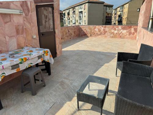 un patio con tavolo e sedie su un balcone di principessa la vigna a Catania