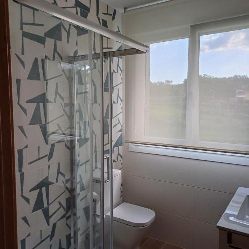 baño con ducha, aseo y ventana en Casa Da Ponte, en Lobios