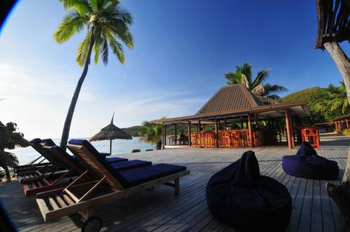 a deck with lounge chairs and a restaurant on the beach at Octopus Resort in Nalauwaki