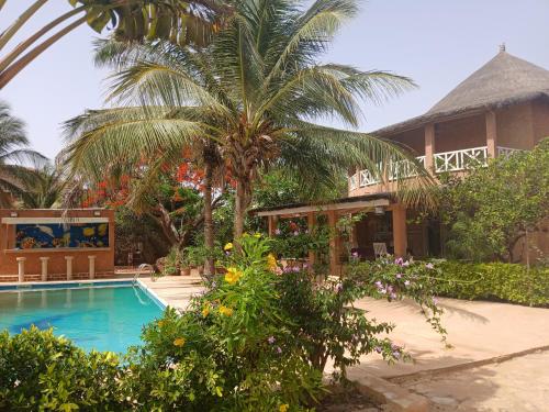 a resort with a swimming pool and a palm tree at Villa Maria in Somone