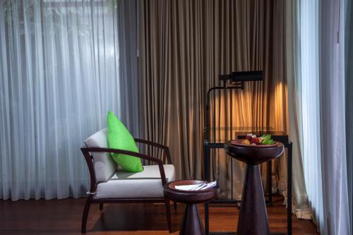 a room with a chair and a bowl of fruit on a table at Sanctoo Suites & Villas in Gianyar
