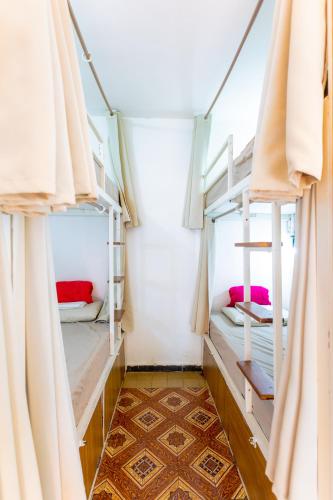 a room with two bunk beds with curtains at Hostel Da Vila Ilhabela in Ilhabela