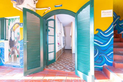 a room with a colorful wall with a door at Hostel Da Vila Ilhabela in Ilhabela