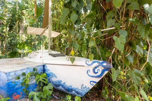 a blue and white toilet sitting next to a tree at Hostel Da Vila Ilhabela in Ilhabela