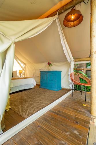 a room with a tent with a bed and a chair at Hostel Da Vila Ilhabela in Ilhabela