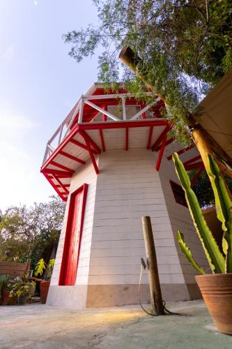a small white building with a red roof at Hostel Da Vila Ilhabela in Ilhabela