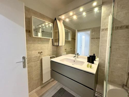 une salle de bain avec un lavabo, une douche et un miroir dans l'établissement Grand Appartement 3 Chambres Bureau - PartDieu, à Lyon