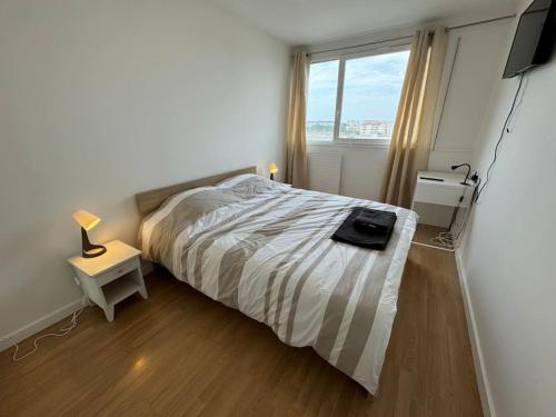 une chambre avec un lit et une grande fenêtre dans l'établissement Grand Appartement 3 Chambres Bureau - PartDieu, à Lyon
