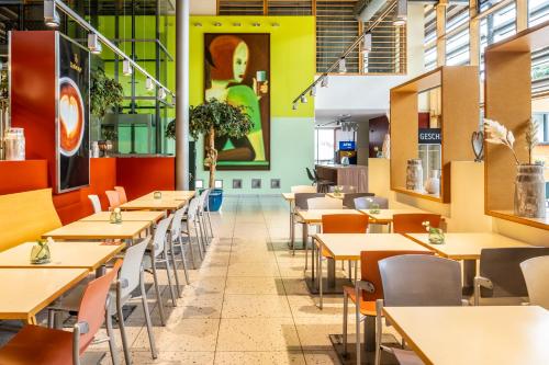 an empty dining room with tables and chairs at Serways Hotel Bruchsal West in Forst